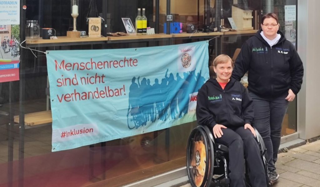 Die beiden Vorsitzenden des Gesamtwerkstattrates präsentieren das Plakat „Menschenrechte sind nicht verhandelbar! #Inklusion“